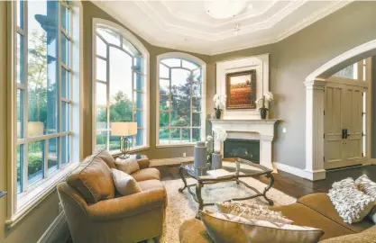  ??  ?? The living room features a soaring ceiling and arched windows.