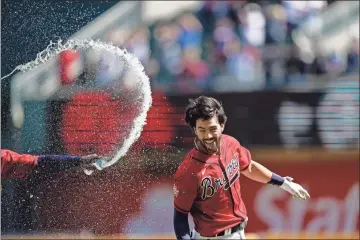  ?? AP - Brynn Anderson ?? Above: The Braves’ Dansby Swanson is splashed by water following his walk-off single in the ninth inning of Thursday afternoon’s game against the Marlins. Below: Ronald Acuña Jr. rounds the bases after hitting a home run — his seventh of the season — in the fifth inning.