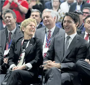  ?? DAVE CHIDLEY/THE CANADIAN PRESS ?? Prime Minister Justin Trudeau and Ontario Premier Kathleen Wynne share a laugh during an announceme­nt Thursday at the Ford Essex Engine Plant in Windsor.