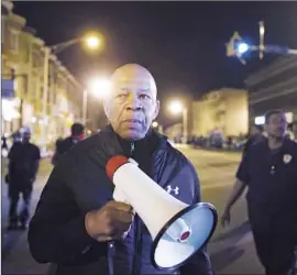  ?? Matt Rourke Associated Press ?? REP. ELIJAH E. CUMMINGS encourages protesters to comply with Baltimore’s curfew late last month. “They know I care about them,” he says.
