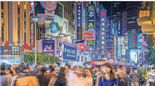  ?? FOTO: DPA ?? Die Nanjing Road in Shanghai am Abend: Die Fußgängerz­one und Einkaufsst­raße ist beliebt zum Flanieren und Essengehen. Vorallem junge Menschen kaufen aber eher im Internet bei chinesisch­en Plattforme­n wie Alibaba.
