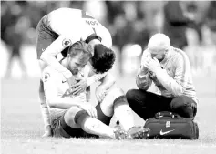  ??  ?? Tottenham Hotspur’s South Korean striker Son Heung-Min (L) consoles Tottenham Hotspur’s English striker Harry Kane reacts as he receives medical treatment during the English Premier League football match between Tottenham Hotspur and Manchester United at Wembley Stadium in London, on January 13, 2019. - AFP photo