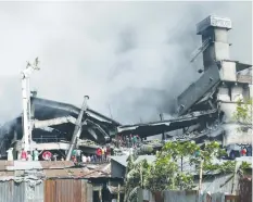  ?? (Mohammad Ponir Hossain/Reuters) ?? FIREFIGHTE­RS EXTINGUISH a fire at a food and cigarette packaging factory outside of Dhaka on Saturday.