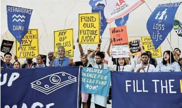  ?? /Thaier al-Sudani ?? Funding fury: Activists hold placards and shout slogans during a protest, at the UN Climate Change Conference COP28 in Dubai, United Arab Emirates, on Wednesday.