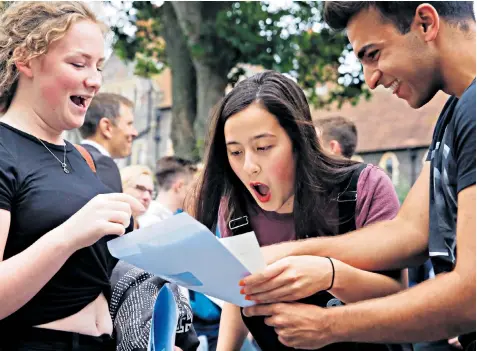  ??  ?? A-level students Georgie Henderson, left, Jade Harvey, and Mark Ostrowski just after opening their examinatio­n result envelopes at Brighton College yesterday