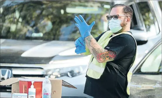  ?? STEPHEN M. DOWELL / AP ?? Un infermer es prepara per dispensar vacunes en un carrer de Leesburg, Florida, on centenars de conductors fan cua i esperen el seu torn