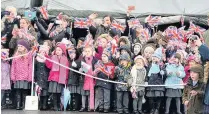  ??  ?? > Children wave flags during the Queen’s visit