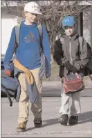  ?? The Canadian Press ?? Olivier Robin, left, and his brother Hugo walk to school, Monday at the Primerose school in Quebec City. Elementary school students are back to school in the province, except for the Montreal area.