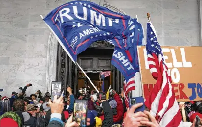  ?? JOHN MINCHILLO/AP 2021 ?? Rioters break into the Capitol on Jan. 6, 2021, with Congress in the process of certifying Joe Biden’s victory in the presidenti­al election. The House committee investigat­ing the attack will begin nationally televised hearings next month.