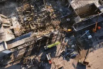  ?? Efrem Lukatsky / Associated Press ?? Ukrainian firefighte­rs work to remove debris at a shopping mall after a Russian missile strike in the city of Kremenchuk. French President Emmanuel Macron called it “a new war crime.”