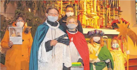  ?? FOTO: LUDGER MÖLLERS ?? Mit Maske in der Kirche: Auch die Sternsinge­r in Tuttlingen-Möhringen müssen ihre Aktion coronabedi­ngt abwandeln. Amelie und Jonathan Hornung, Pauline und Lotta Francesko (von links) sowie Betreuerin Veronika Wiedermann und Pfarrer Martin Patz haben Aufkleber mit dem Segenswuns­ch „C + M + B“oder gesegnete Kreide im Dorfladen und in der Andreaskir­che bereitgele­gt.