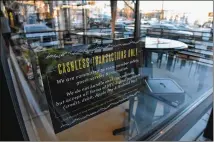  ?? HYOSUB SHIN / HSHIN@AJC.COM ?? “Cashless Transactio­ns Only” reads the sign on the window of The Local Pizzaiolo in Atlanta. Many restaurant­s are banning dollars because of safety reasons and to free up managers to focus on higher priorities.