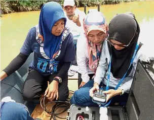  ??  ?? Gauging the damage: Researcher­s checking the quality of water from one of the rivers within the wetlands.