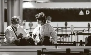  ?? Wally Skalij / Los Angeles Times ?? At some airports, none of the protective gear worn by these travelers in Los Angeles is required.