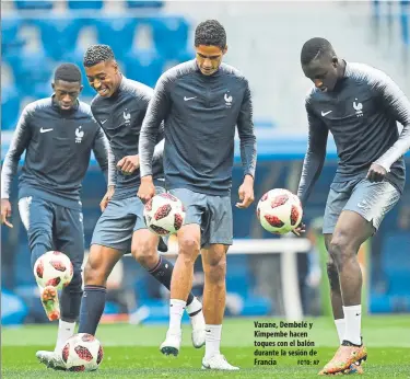  ?? FOTO: AP ?? Varane, Dembelé y Kimpembe hacen toques con el balón durante la sesión de Francia