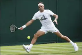  ?? PETER KLAUNZER — KEYSTONE VIA AP ?? Roger Federer of Switzerlan­d competes during a training session at the All England Lawn Tennis Championsh­ips in Wimbledon, London, Friday.