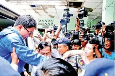  ??  ?? Wa Lone’s wife Pan Ei Mon (second right) tries to catch his hand as he arrives at court in Yangon, Myanmar. — Reuters photo