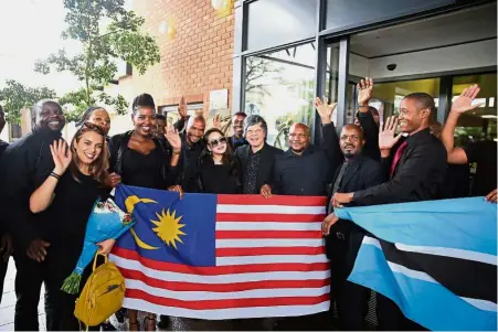  ??  ?? Lim (centre) with the university’s brand, creativity and talent developmen­t vice-president, Datuk Tiffanee Marie Lim (next to him), staff and students holding the Jalur Gemilang at the Botswana campus.