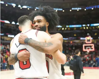  ?? ?? Coby White, right, hugs teammate Zach LaVine after Friday’s win over the Hornets. JOHN J. KIM/CHICAGO TRIBUNE