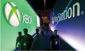  ?? Photograph: Lucy Nicholson/Reuters ?? Attendees walk past a Microsoft Xbox sign opposite a Sony PlayStatio­n sign at E3 in 2015.