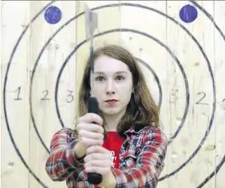  ?? MARIE-FRANCE COALLIER ?? Kayla Henry gets set to throw an axe at Bad Axe Throwing on Couture Blvd. in the east end. “Once you’ve thrown an axe, you won’t go back to darts,” says Dominique Jégu of Maniax in St-Léonard.