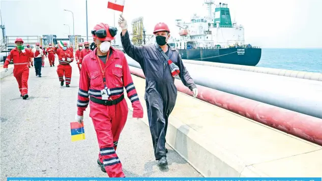  ??  ?? PUERTO CABELLO: A worker of the Venezuelan state oil company PDVSA waves an Iranian flag as the Iranian-flagged oil tanker Fortune docks at the El Palito refinery in Puerto Cabello, in the northern state of Carabobo, Venezuela, on Monday. — AFP