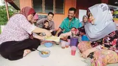  ??  ?? CHE Wan Minah (kanan) bersama mangsa banjir yang lain berkongsi makanan di Pusat Pemindahan Bencana Surau Kampung Besol Lama.