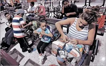  ?? DAVID J. PHILLIP/AP ?? Honduran immigrant Elyse Hernandez, right, waits Saturday with daughter Genesis, center, and son Jorge David, left, inside a bus station in McAllen, Texas. The family slept on a bridge for three days before entering the United States.