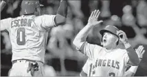  ?? Jason O. Watson Getty Images ?? DANNY ESPINOSA is greeted by Angels teammate Yunel Escobar after hitting a three-run home run in the ninth inning.