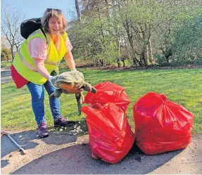  ?? An EKCLP volunteer bags it up ?? Clean sweep