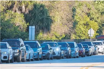  ?? JOE CAVARETTA/SOUTH FLORIDA SUN SENTINEL ?? Cars line up at the COVID-19 vaccine site at Snyder Park in Fort Lauderdale on Tuesday. The site was moved from Holiday Park to Snyder Park because the location makes it easier to give more shots.