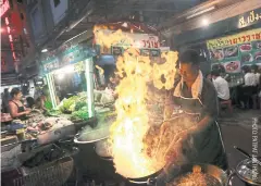  ??  ?? COOKING UP A STORM: Vendors prepare food on Yaowarat Road.