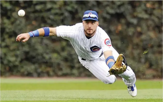  ??  ?? CHICAGO: Chicago Cubs center fielder Albert Almora Jr. misses a single hit by St Louis Cardinals’ Jose Martinez during the fourth inning of a baseball game Sunday, in Chicago. — AP