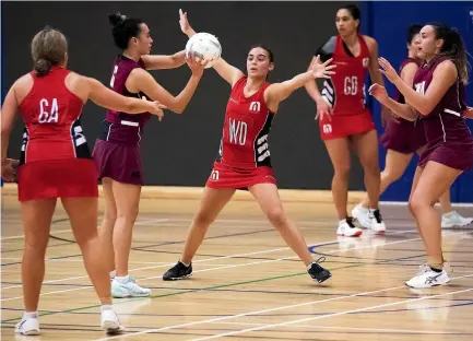  ?? DAVID UNWIN/STUFF ?? Manukura Red’s Jasmine Heaney, centre, in full stretch trying to defend against College Old Girls A1 at the Arena on Tuesday night.