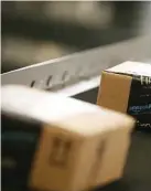  ??  ?? Boxes move along a conveyor belt at an Amazon fulfillmen­t center in Tracy, Calif.