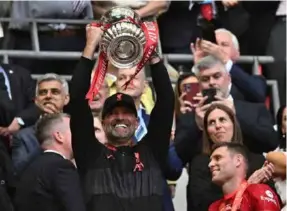  ?? AFP/VNA Photo ?? TOP OF THE KLOPPS:
Liverpool's German manager Jurgen Klopp
celebrates with the trophy after winning the English FA Cup final football match between Chelsea and Liverpool,
at Wembley stadium, in London, on Saturday.