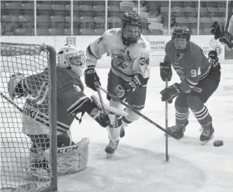  ?? JEREMY FRASER/CAPE BRETON POST ?? Alex Chenhall of the Sydney Academy Wildcats, centre, chases the loose puck as Glace Bay Panthers teammates Darian MacInnis, left, and Matthew Crane watch during Cape Breton High School Hockey League action at the Membertou Sport and Wellness Centre in October. High school hockey has been given the green light to return to play, however, due to exam week, action won’t resume earlier than Thursday.