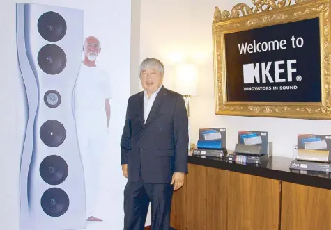  ??  ?? Co Ban Kiat Hardware Inc. chairman and president Johnny Cobankiat stands beside the life-size image of the iconic KEF Muo speaker and its famous designer Ross Lovegrove.