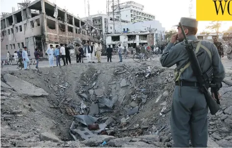  ?? RAHMAT GUL / THE ASSOCIATED PRESS ?? Security forces stand next to a crater created by a massive explosion in front of the German Embassy in Kabul, Afghanista­n, on Wednesday.