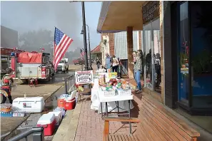  ?? Photo by Kate Stow ?? ■ Members of the community provide drinks and food for firefighte­rs battling a blaze Thursday in downtown Atlanta, Texas. Robin Betts, Atlanta fire chief and fire marshal, shared Facebook photos of the residents with a class in Huntsville, Texas. He said other chiefs were amazed at such a sense of community.