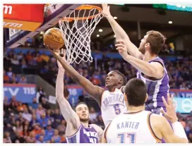  ??  ?? Thunder guard Victor Oladipo (5) shoots between Kings center Kosta Koufos (41) and center Georgios Papagianni­s, right, in the second quarter of an NBA basketball game in Oklahoma City on Saturday night. (AP)