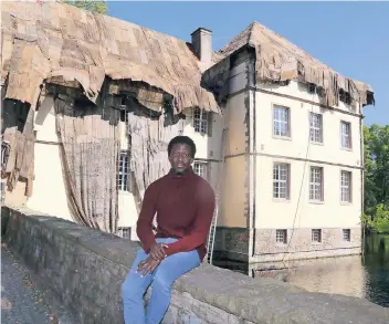  ??  ?? In ein Lumpenklei­d aus alten ghanaische­n Kohlesäcke­n hüllt der Künstlers Ibrahim Mahama Schloss Strünkede in Herne. „Coal Market“heißt das Kunstwerk.