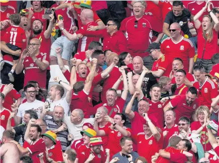  ??  ?? Main picture: Wales supporters celebrate Wales’ first goal against Slovakia during the UEFA Euro 2016 Championsh­ip in Bordeaux yesterday, and then went on to experience the whole range of joy and tension during the game, below