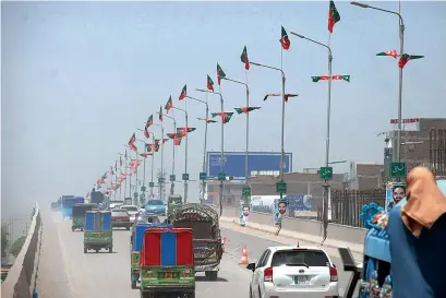  ?? APP ?? Flags of different political parties installed on street light poles flutter at a flyover in Peshawar on Monday. —