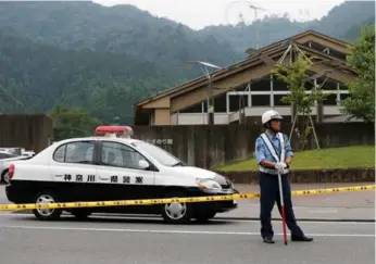  ?? ISSSEI KATO/REUTERS ?? A police officer stands guard at a facility for the disabled, where a man killed 19 and injured 20 others.