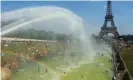  ?? Photograph: Owen Franken - Corbis/Getty Images ?? People cool off in and around a large water pool at Trocadero, across the Seine from the Eiffel Tower.