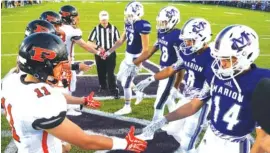  ?? STAFF PHOTO BY ROBIN RUDD ?? The captains shake hands before the coin toss in the 2017 game between South Pittsburg and Marion County.