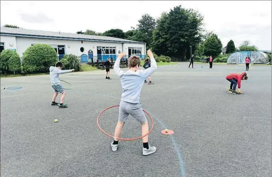  ?? REBECCA NADEN / REUTERS ?? Els professors d’una escola a Tenby, Gal·les, expliquen als alumnes les normes de distància social en la reobertura del 29 de juny