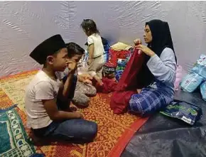  ?? ?? Yasmin Syafiqah bersama tiga anaknya antara terpaksa berpindah ke PPS SMK Beris Panchor.