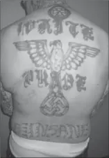  ??  ?? Tattoos cover Billy Cummer.
Above: The words n “White Power” and two pistols adorn his belly.
Left: Cummer n shows off the massive “White Pride” tattoo on his back. There’s also an eagle and a swastika, plus the word “Insane.”